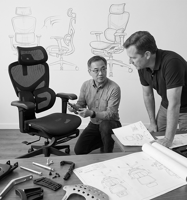 Engineers reviewing chair prototype in black and white